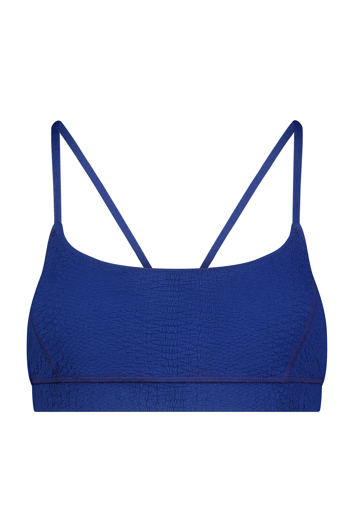 The Emery Bra by Gigi C Sport is a blue, minimalist bralette with thin straps and breathable, textured knit fabric, elegantly laid flat against a white background.