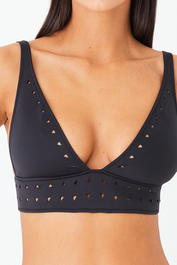 The Angelica Top by Gigi C Bikinis is a black bikini top featuring geometric lasercut patterns, a V-shaped neckline, and thick straps, shown against a plain white background.