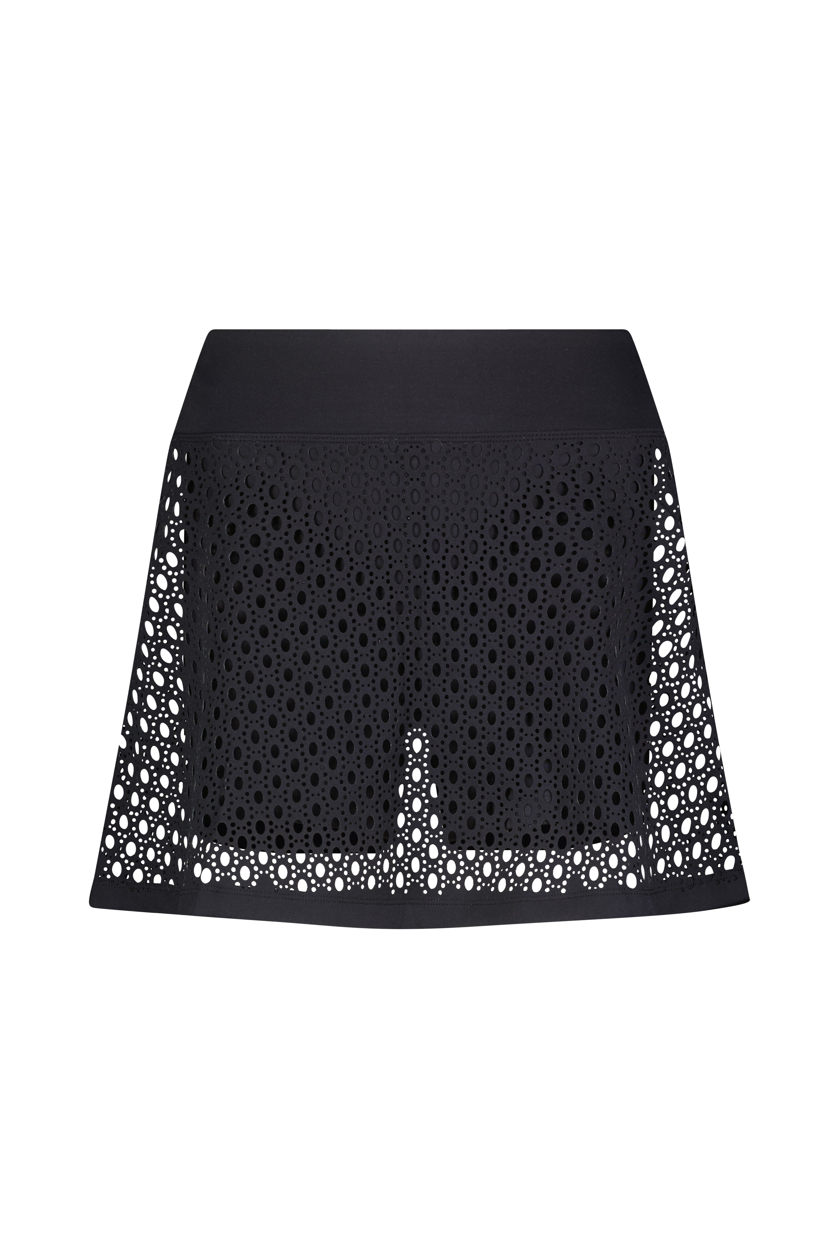 The Kyra Skirt by Gigi C Sport is a black mini skirt featuring eyelet lace detailing and a solid waistband, transitioning into circular cutouts for an elegant yet athleisure-inspired design.