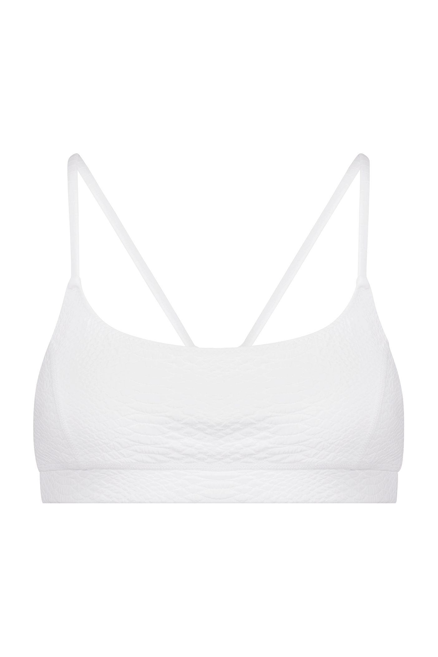 Discover the Gigi C Sport Emery Bra: a white bralette with a textured pattern, thin double straps with loop detail, and breathable knit construction against a black backdrop for ultimate comfort and style.